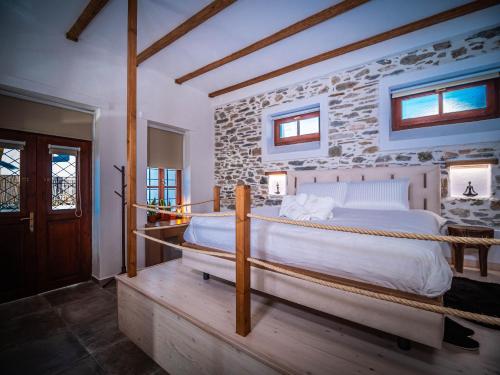 a bedroom with a bed and a stone wall at SELO Luxury Suite in Álli Meriá