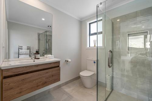 a bathroom with a toilet and a glass shower at Harakeke Holiday Haven - Taupo in Taupo