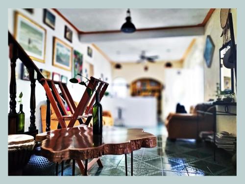 a bottle of wine sitting on a wooden chair in a living room at Casa del Pintor Chetumal in Chetumal