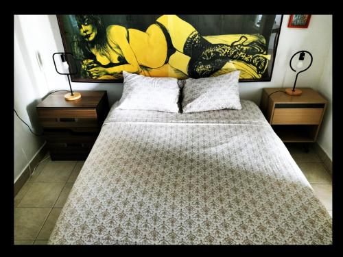 a bedroom with a large bed with two night stands at Casa del Pintor Chetumal in Chetumal