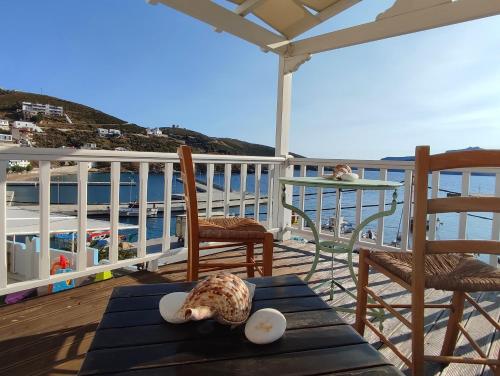 a deck with chairs and a table with a shell on it at Aglaia studios fournoi in Fourni Ikarias