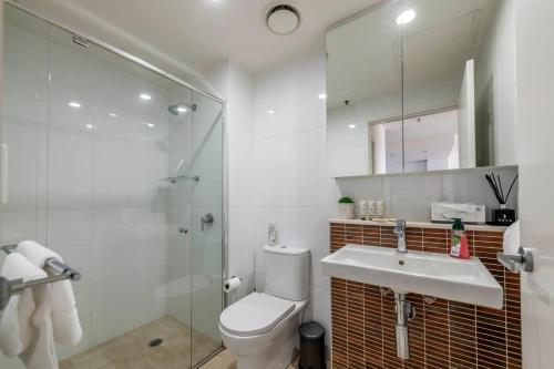 ein Bad mit einem WC, einem Waschbecken und einer Dusche in der Unterkunft Sensational City Apartment with Lake Views - Benjamin Way ACT in Canberra