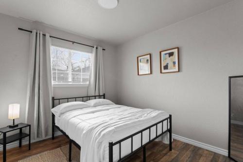 a white bedroom with a bed and a window at Steps to Lackland AFB & SeaWorld in San Antonio