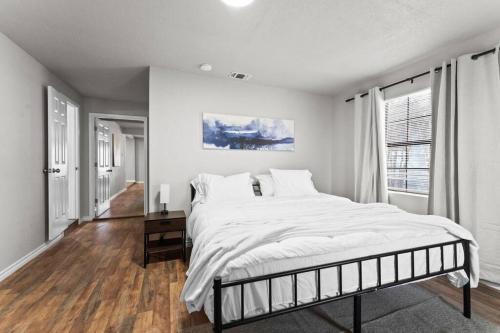 a white bedroom with a large bed and a window at Steps to Lackland AFB & SeaWorld in San Antonio