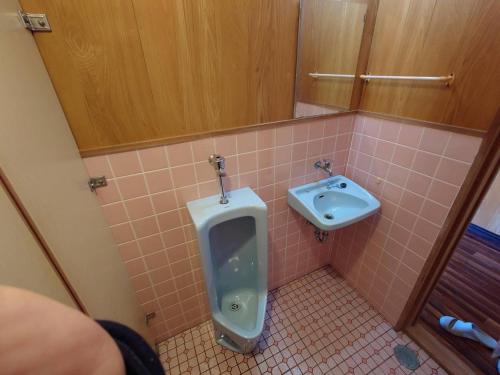 a bathroom with a urinal and a sink at 39guest house in Ibusuki