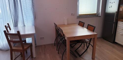 a kitchen with a wooden table and chairs at Bright by Trade Fair ICM 15 min direct to City Center 2-BedRoom full 2-BathRoom, free Parking, Balcony, Family and Business friendly in Feldkirchen