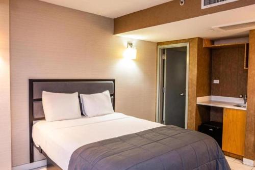 1 dormitorio con 1 cama blanca grande y cocina en Hotel Moca NYC en Nueva York