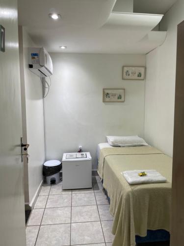 ペトロリーナにあるPousada Cantinho do Sossegoのベッド2台とテーブルが備わる小さな客室です。