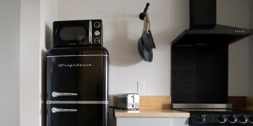 a refrigerator with a microwave on top of it in a kitchen at Boardwalk Cottages in Long Beach