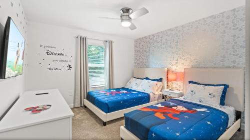 a bedroom with two beds and a desk at Stunning Townhouses 5 Minutes away Disney! in Kissimmee