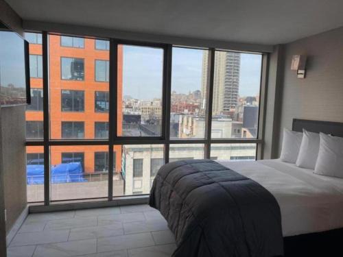 a bedroom with a bed and a large window at Hotel Moca NYC in New York