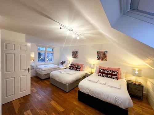 a bedroom with two beds and a room with a door at Beahive house in Redbridge