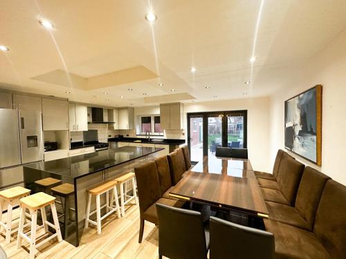 a large kitchen with a long table and chairs at Beahive house in Redbridge