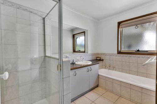 Un baño con bañera, lavabo y ducha. en Sheerwater Jetty, en Paynesville