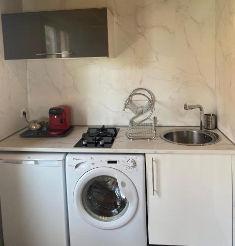 a kitchen with a washing machine and a sink at La casa de Bianca in Teyran