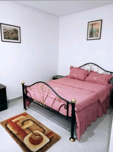 a bedroom with a pink bed with a pink bedspread at Bella casa in Dakar