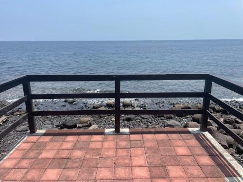a bench sitting on the shore of the ocean at Absolute Beachfront, Paradise, 3BR Villa with Private Pool on 1200m2 of Tropical Land in Tulamben
