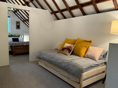 a bed with pillows on it in a room at The Stables at Rosevale in Bathurst