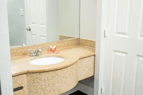 een badkamer met een wastafel en een spiegel bij Econo Lodge Summit - Scranton in Clarks Summit