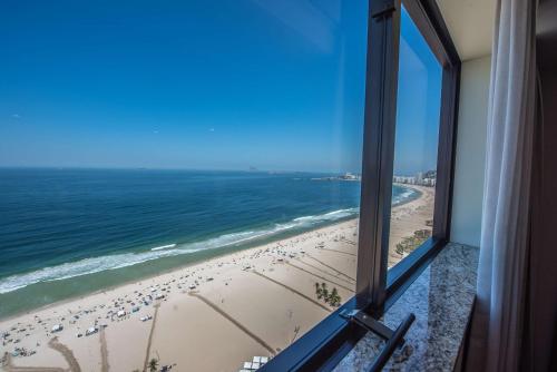 a view of a beach from a window at Hilton Copacabana Rio de Janeiro in Rio de Janeiro