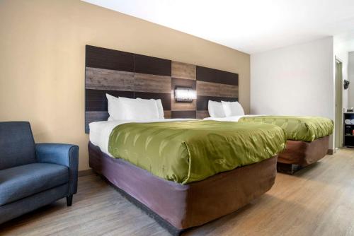 una habitación de hotel con 2 camas y una silla en Quality Inn & Conference Center Panama City, en Panama City
