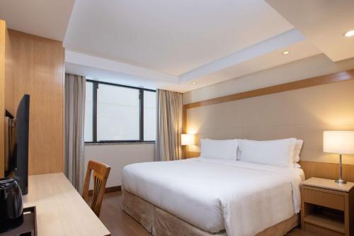 a hotel room with a large bed and a television at Hilton Copacabana Rio de Janeiro in Rio de Janeiro