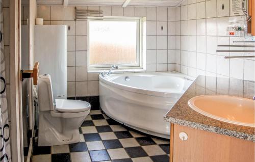 y baño con bañera, aseo y lavamanos. en Stunning Home In Rudkbing With Sauna, en Spodsbjerg