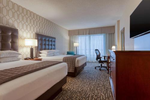 チェスターフィールドにあるDrury Plaza Hotel St. Louis Chesterfieldのベッド2台、薄型テレビが備わるホテルルームです。