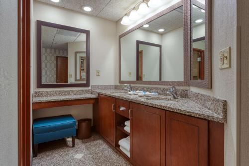 a bathroom with two sinks and two mirrors at Drury Plaza Hotel St. Louis Chesterfield in Chesterfield