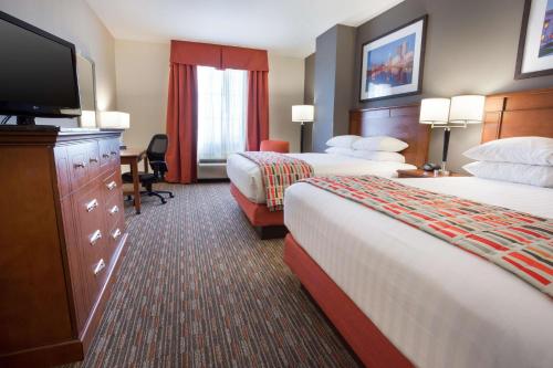 Drury Inn & Suites Columbus Grove City في غروف سيتي: غرفة فندقية بسريرين وتلفزيون بشاشة مسطحة
