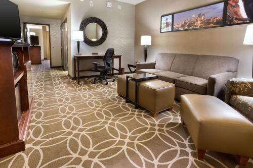 a living room with a couch and a desk at Drury Inn & Suites Louisville North in Louisville