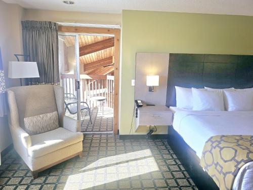a hotel room with a bed and a chair at Baymont by Wyndham Rolla in Rolla