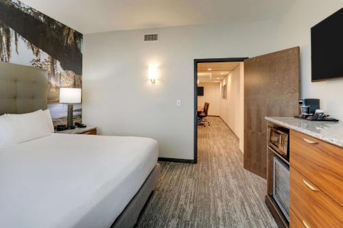 a hotel room with a bed and a kitchen at Drury Plaza Hotel Tallahassee in Tallahassee