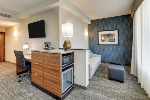 a hotel room with a bed and a desk and a couch at Drury Plaza Hotel Tallahassee in Tallahassee