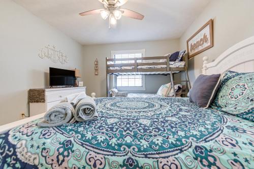 ein Schlafzimmer mit einem Bett und einem Etagenbett in der Unterkunft Sunny North Myrtle Beach Home Walk to Ocean! in Myrtle Beach