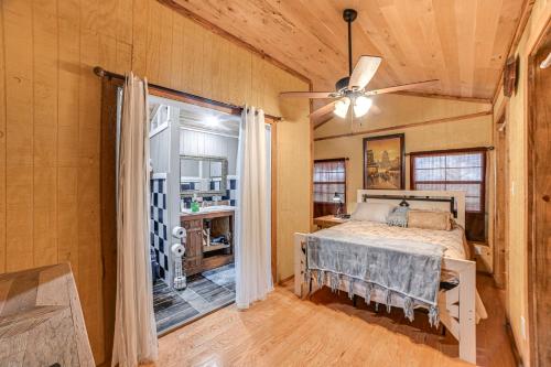 een slaapkamer met een bed en een plafondventilator bij Kentucky Countryside Cabin Near Fort Campbell in Oak Grove