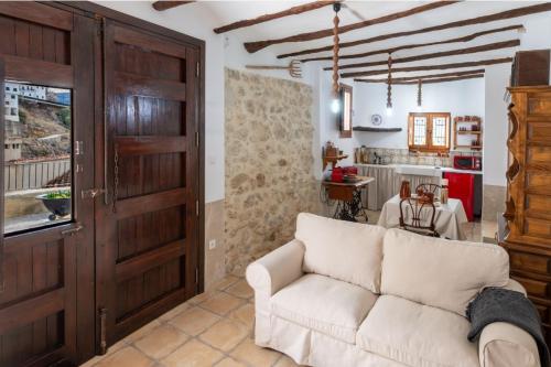 a living room with a white couch and a door at Casa Rural La Corretger in Chulilla