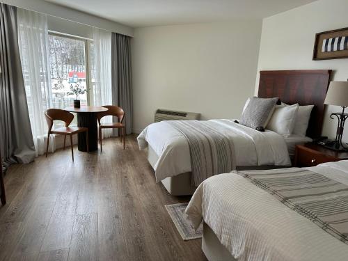una camera d'albergo con due letti e un tavolo di Foxburg Inn a Emlenton