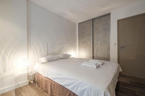 une chambre avec un lit blanc avec des serviettes dessus dans l'établissement WDF two bedrooms in the heart of Cannes!!, à Cannes