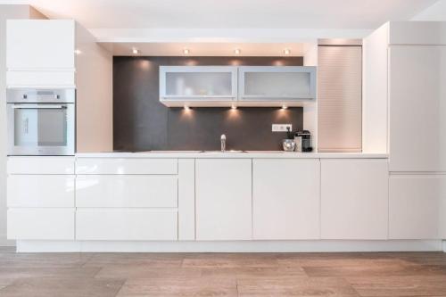 une cuisine avec des armoires blanches et un évier dans l'établissement WDF two bedrooms in the heart of Cannes!!, à Cannes