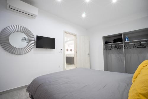 a white bedroom with a bed and a mirror at Rodini House in Rhodes Town