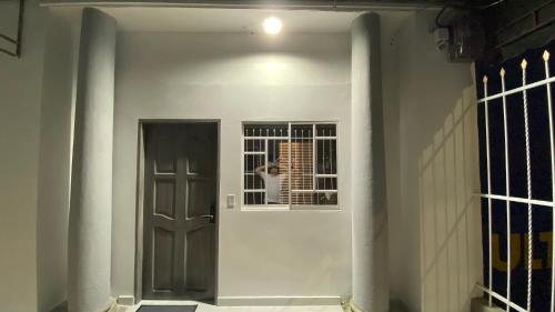 un pasillo con una puerta y una persona mirando por la ventana en Hospedaje Catedral 55, en Barranquilla