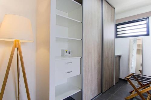 a room with white shelves and a lamp at Appartement Corail Bleu in Fort-de-France