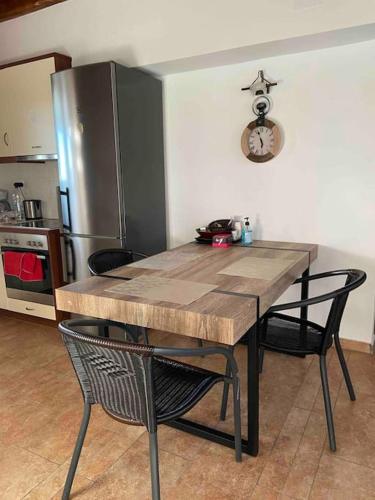 a kitchen with a wooden table with chairs and a refrigerator at House by the beach,next to village,sunset view in Finikas