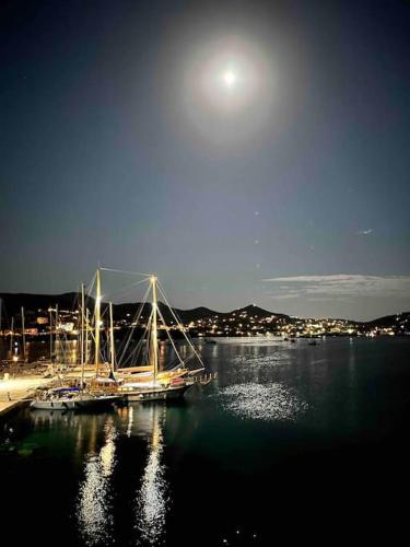 a boat docked at a dock in a body of water at House by the beach,next to village,sunset view in Finikas