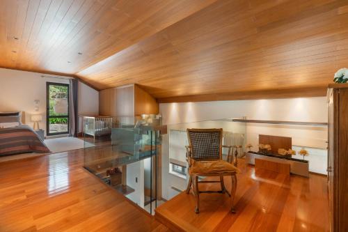 a living room with a glass table and a chair at Confluentia H&A - XIII Century Loft House in Coimbra