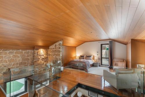 a room with a bed and a stone wall at Confluentia H&A - Luxury XIII Century Loft House in Coimbra