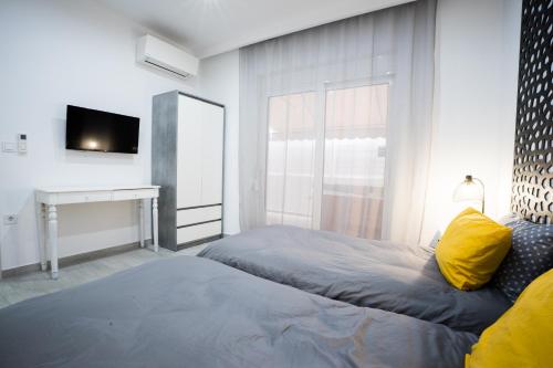a bedroom with a bed and a tv and a window at Rodini House in Rhodes Town