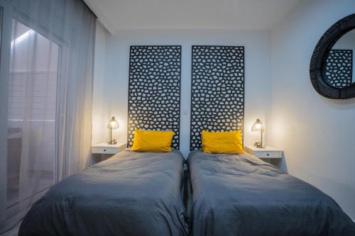 a bedroom with two beds with yellow pillows at Rodini House in Rhodes Town
