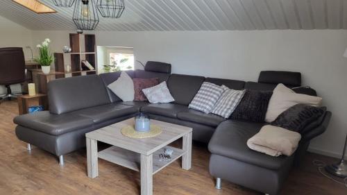 a living room with a black leather couch and a table at Relax FeWo in Bayerisch Gmain
